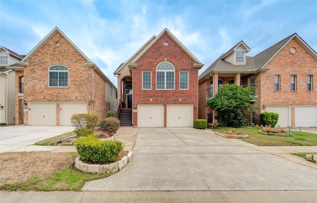 traditional home featuring concrete driveway, brick siding, stairway, and an attached garage