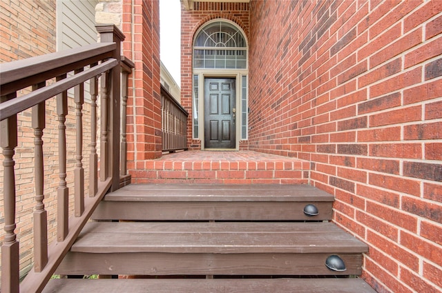 doorway to property featuring brick siding