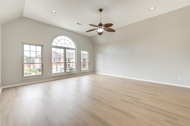 empty room featuring visible vents, baseboards, a ceiling fan, lofted ceiling, and light wood-style floors