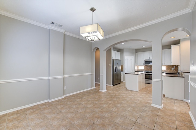 kitchen featuring dark countertops, white cabinetry, stainless steel appliances, and a sink