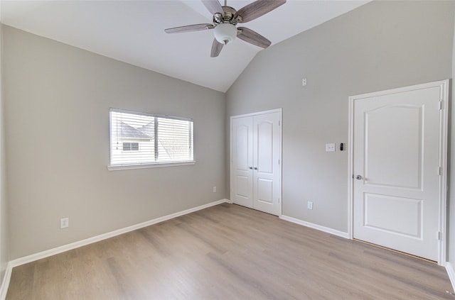 unfurnished bedroom featuring a closet, vaulted ceiling, ceiling fan, light wood-type flooring, and baseboards