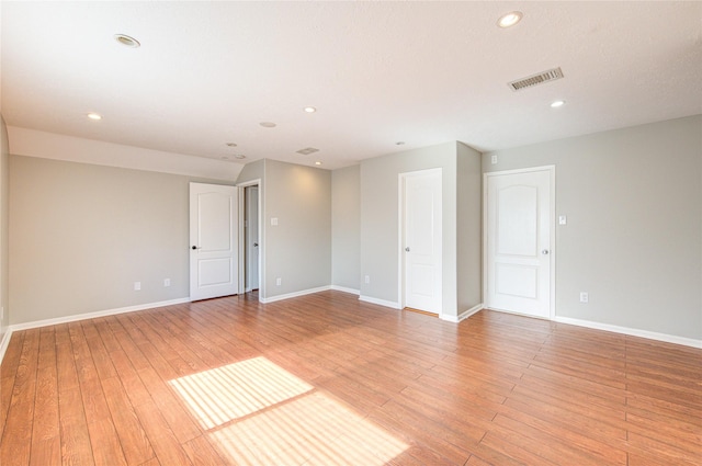 spare room with light wood finished floors, baseboards, visible vents, and recessed lighting