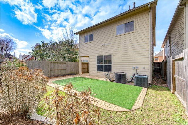 rear view of house featuring a fenced backyard, central AC unit, and a lawn