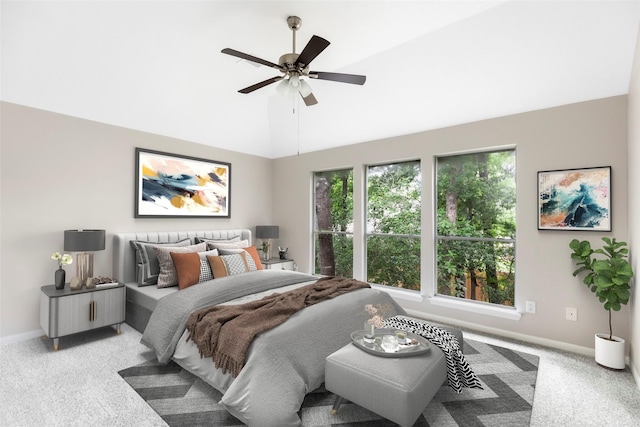 bedroom with light carpet, ceiling fan, baseboards, and vaulted ceiling