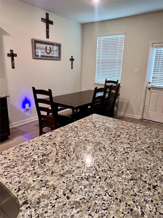 dining area with baseboards and wood finished floors