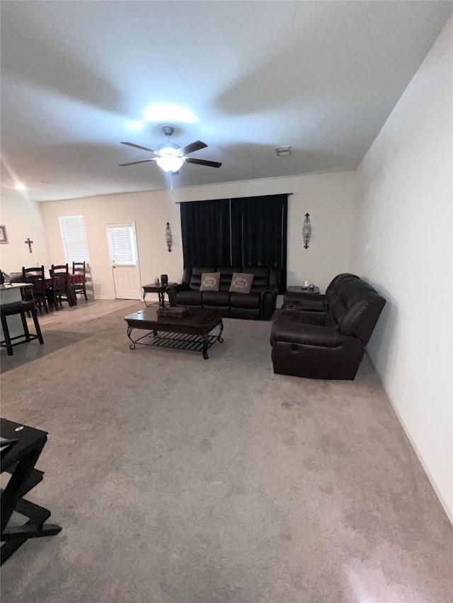 living room with visible vents, a ceiling fan, and carpet