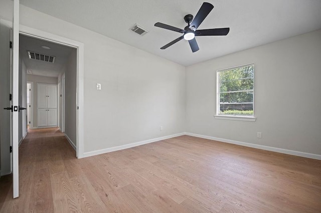 unfurnished room featuring light wood-style floors, baseboards, and visible vents