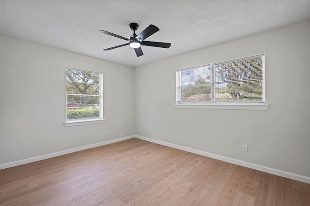 unfurnished room with baseboards, a textured ceiling, a ceiling fan, and light wood-style floors