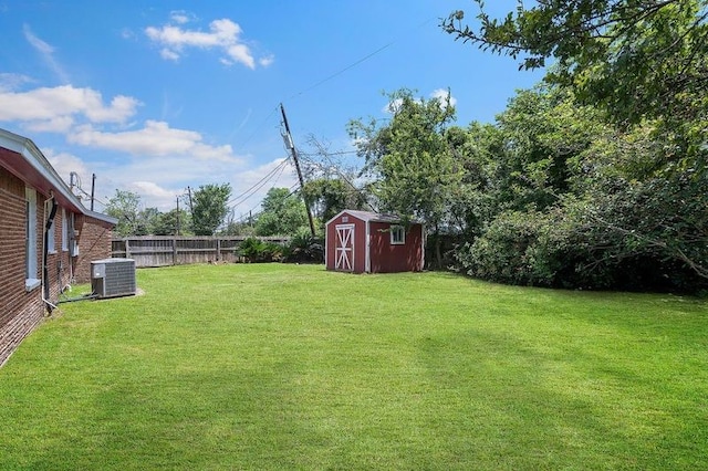 view of yard featuring an outbuilding, central AC, a shed, and fence