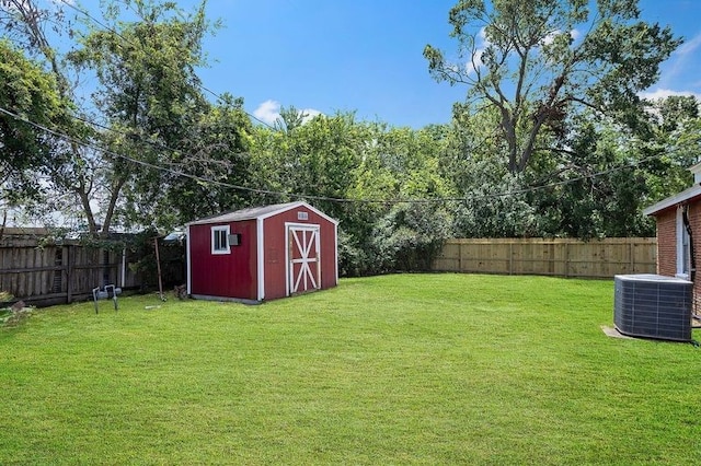 view of yard with an outbuilding, central AC, a storage unit, and a fenced backyard