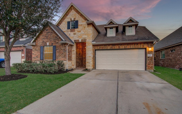 view of front of home featuring driveway, stone siding, a front yard, an attached garage, and brick siding