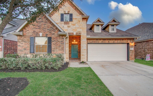 view of front of property featuring a front yard, driveway, an attached garage, stone siding, and brick siding