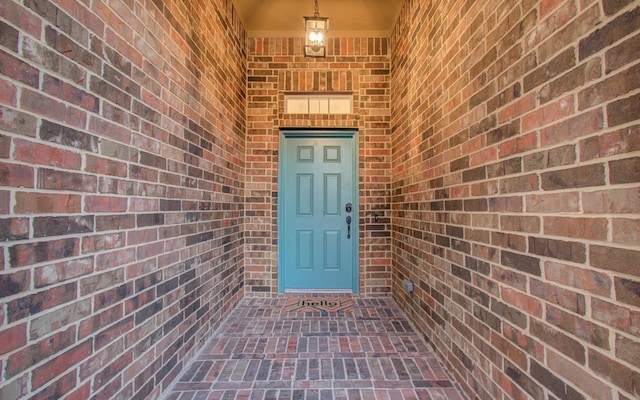 property entrance featuring brick siding