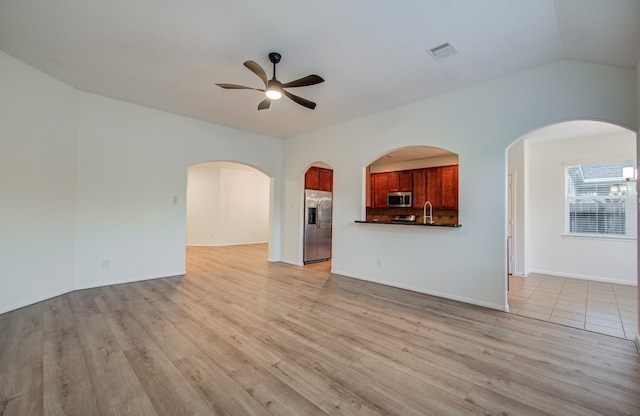 unfurnished living room featuring visible vents, lofted ceiling, ceiling fan, and light wood-style flooring