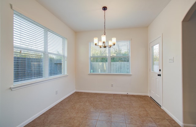 unfurnished dining area with light tile patterned floors, arched walkways, baseboards, and a chandelier