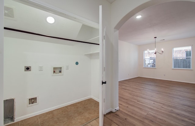 clothes washing area featuring baseboards, washer hookup, an inviting chandelier, arched walkways, and electric dryer hookup