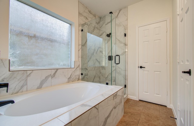 bathroom with a marble finish shower and a garden tub