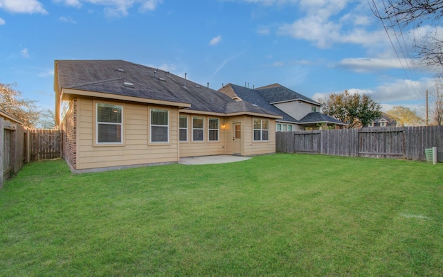 rear view of house featuring a patio, a yard, and a fenced backyard