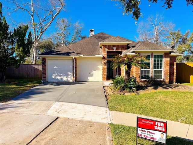 view of front of house with a garage, brick siding, concrete driveway, fence, and a front yard