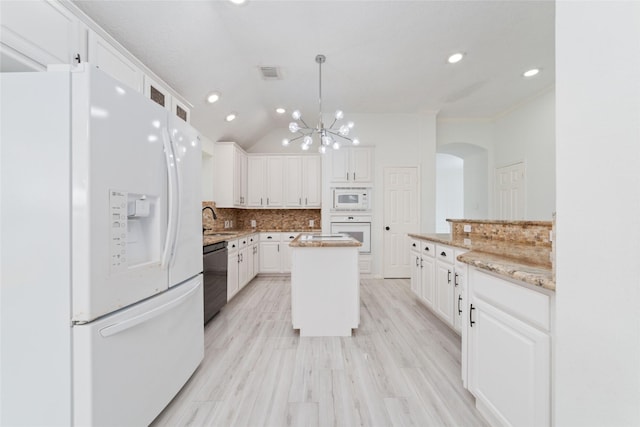 kitchen with white appliances, a kitchen island, light wood-style floors, white cabinetry, and backsplash