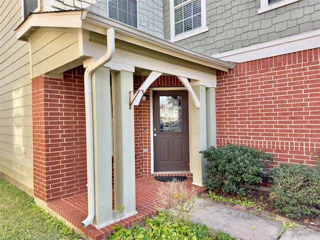 view of exterior entry with brick siding