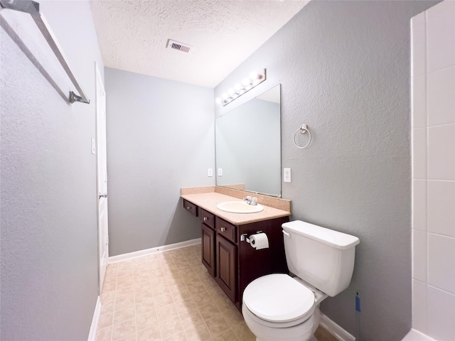 bathroom with a textured wall, toilet, a textured ceiling, vanity, and baseboards