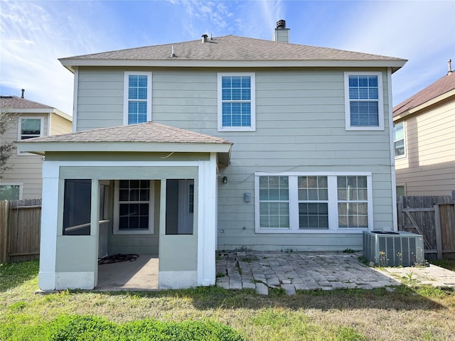 rear view of house featuring a chimney, roof with shingles, fence, cooling unit, and a patio area