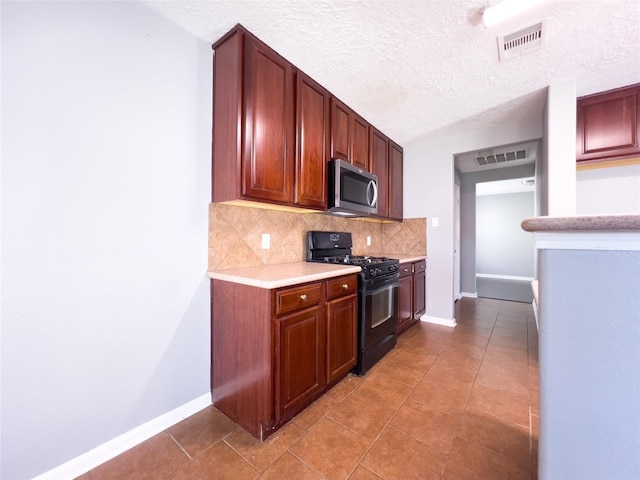 kitchen with black gas range, visible vents, light countertops, backsplash, and stainless steel microwave