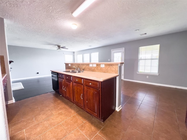 kitchen featuring a sink, visible vents, light countertops, backsplash, and dishwasher