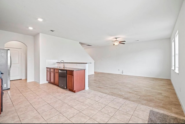 kitchen featuring arched walkways, visible vents, a ceiling fan, freestanding refrigerator, and a sink