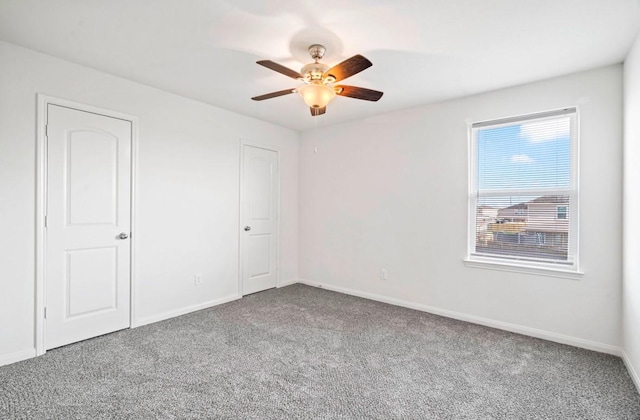 unfurnished bedroom with carpet floors, baseboards, and a ceiling fan