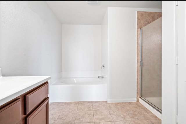 bathroom featuring vanity, a shower stall, a bath, and tile patterned floors