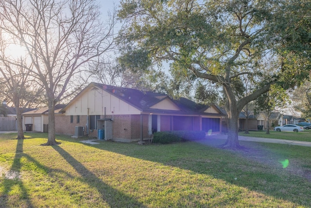 view of side of property featuring brick siding, a lawn, and central AC unit