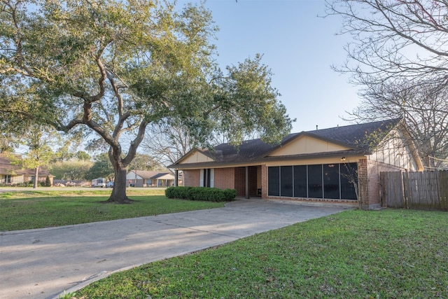 view of front facade featuring brick siding, a front lawn, and fence