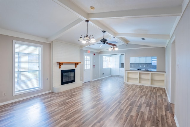 unfurnished living room with vaulted ceiling with beams, light wood finished floors, baseboards, and a large fireplace