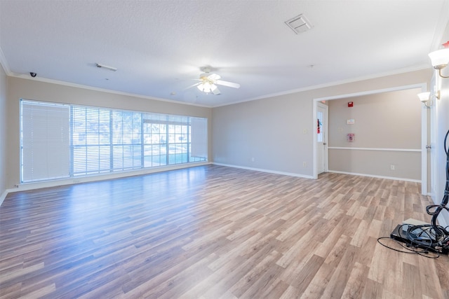 unfurnished living room featuring a ceiling fan, light wood-type flooring, visible vents, and crown molding