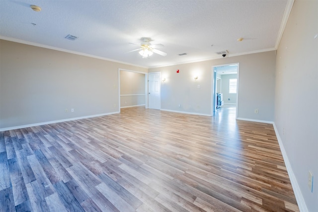 spare room featuring ornamental molding, ceiling fan, light wood-style flooring, and visible vents