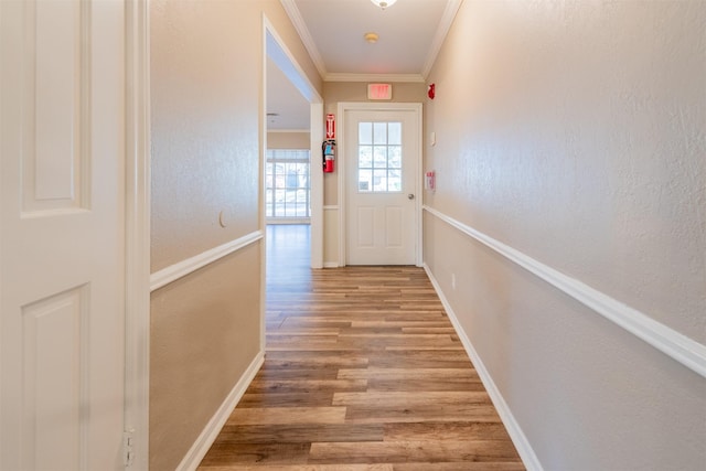 doorway to outside with baseboards, wood finished floors, and crown molding