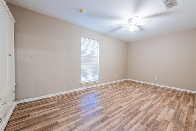 spare room with ceiling fan, baseboards, visible vents, and light wood-style floors