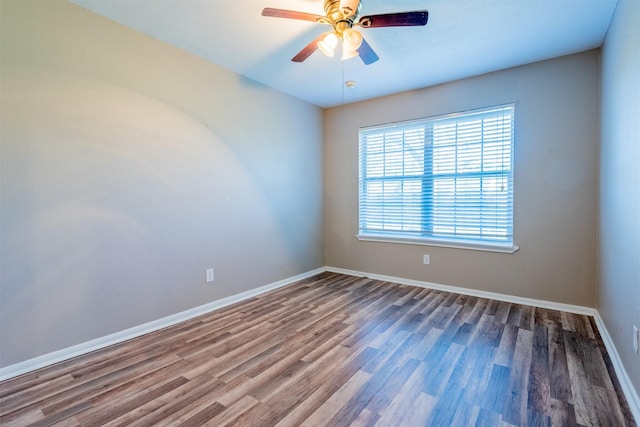 empty room featuring a ceiling fan, baseboards, and wood finished floors