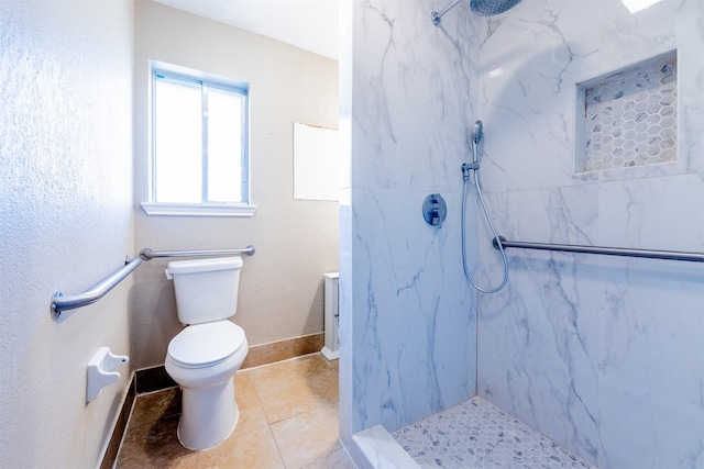 bathroom with tile patterned flooring, a marble finish shower, baseboards, and toilet