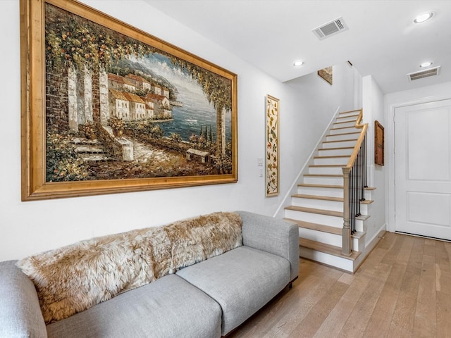 living area with stairs, visible vents, hardwood / wood-style floors, and recessed lighting