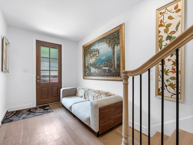 entryway featuring stairway, hardwood / wood-style flooring, and baseboards