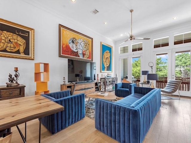 living area featuring light wood finished floors, recessed lighting, visible vents, ornamental molding, and a ceiling fan