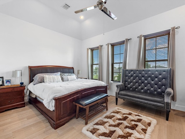 bedroom featuring lofted ceiling, ceiling fan, visible vents, baseboards, and light wood-type flooring