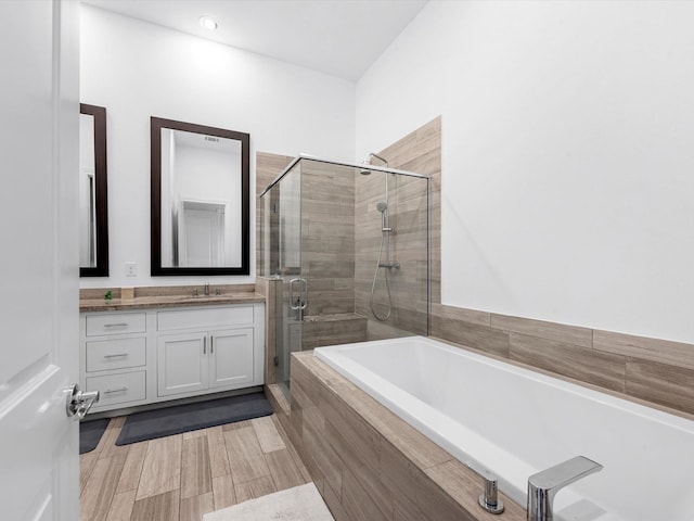 bathroom with a garden tub, a shower stall, and vanity