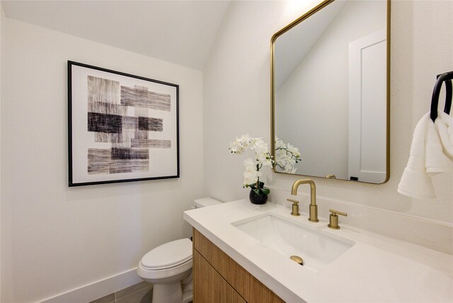 half bath with lofted ceiling, baseboards, vanity, and toilet