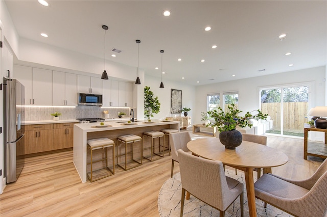 dining space featuring recessed lighting, visible vents, and light wood-style floors