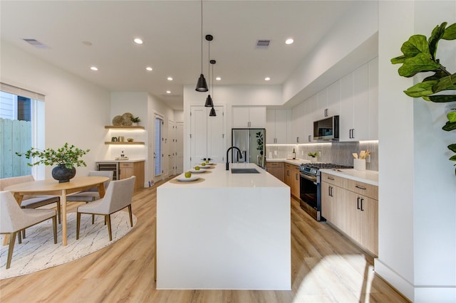 kitchen featuring tasteful backsplash, visible vents, light wood-style flooring, stainless steel appliances, and light countertops