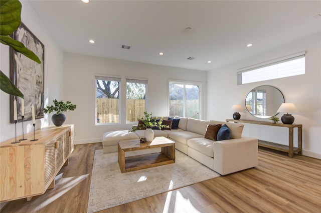 living room featuring baseboards, wood finished floors, visible vents, and recessed lighting